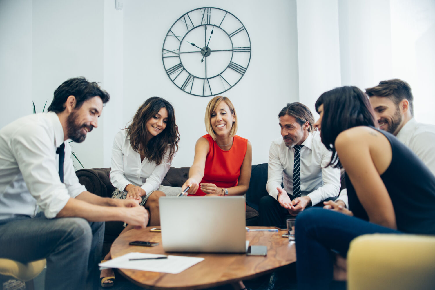 ressources-humaines Cinq personnes en discussion autour d’un PC, échangeant sur des sujets de ressources humaines dans un cadre collaboratif.